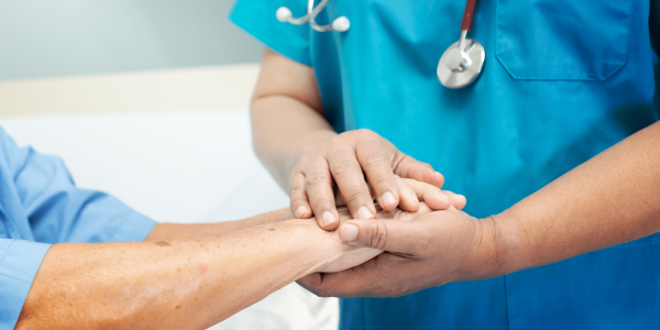 healthcare professional holding a patient's hand